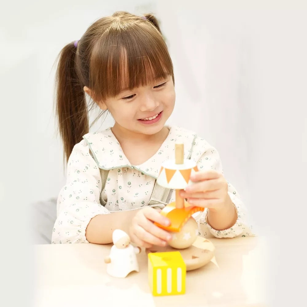 Balansuojantis klaunas ant medinių kaladėlių piramidės